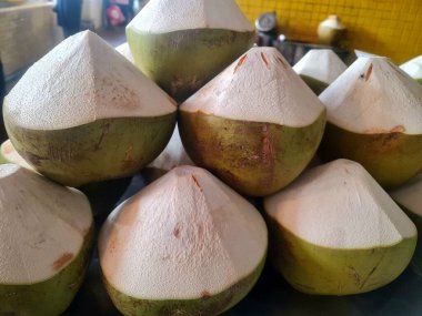 Genç hindistan cevizleri yerel tropikal markette içmek için hazırlanıyor.