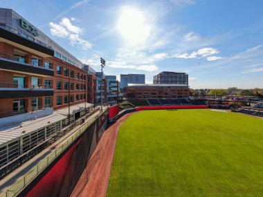 Durham Bulls Atletizm Parkı 'ndan güneşe doğru geniş açılı hava görüntüsü. Parlak güneş yeşil çim üzerinde parlıyor, kırmızı uyarı hattı, ve sol alan çizgisi boyunca BCG ofis binası.