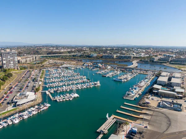 Okyanus kıyısındaki panorama yelkenli ve yatlarla dolu. Manzarada limanın sakin turkuaz suyu, ikonik deniz feneri ve uzaktaki Oceanside İskelesi ile San Luis Rey Nehri 'ni geçen bir köprü yer alıyor..