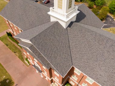 Wake Forest, NC 'de büyük bir mimari çatı sisteminin havadan görüntüsü. Özellikler arasında merkezi beyaz bir kubbe, hassas kaplamalı birden fazla kesişen çıkıntılar ve temiz tuğla entegrasyonu yer alıyor..