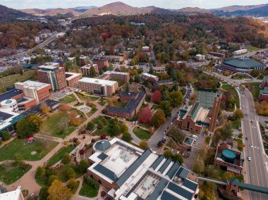 Bir hava aracı, sonbahar yaprak mevsiminde Boone şehir merkezinin kalbini yakalar. Şehrin mimarisi ve yerel sokakları Blue Ridge Dağı 'nın kıvrımlı tepelerinin canlı zeminine dayanır..
