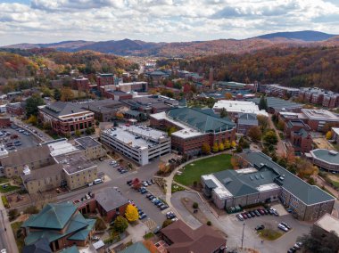Geniş bir hava manzarası, Boone kasabası içinde yer alan Appalachian Eyalet Üniversitesi kampüsünü yakalar. Sahne, Blue Ridge 'in canlı sonbahar sırtlarıyla çevrili akademik binaları ve yerel caddeleri gösteriyor..