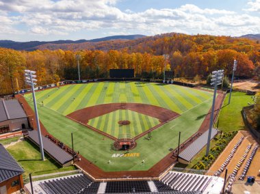 Jim ve Bettie Smith Stadyumu 'ndaki Kunduz Sahası' nı kapsayan geniş bir insansız hava aracı görüntüsü sonbaharda zirveye ulaşır. Appalachian Eyalet Üniversitesi beyzbol tesisi Boone 'daki Blue Ridge Dağları' nın canlı kırmızı ve altın yaprakları arasında yer almaktadır..