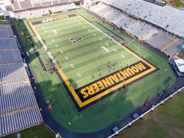 Kidd Brewer Stadyumu 'ndaki yüksek insansız hava aracı atışı, Appalachian Eyalet Üniversitesi futbol takımını sahada sergiliyor. Kaya olarak bilinen siyah ve altın çim bu Boone, Kuzey Carolina 'nın odak noktasıdır..