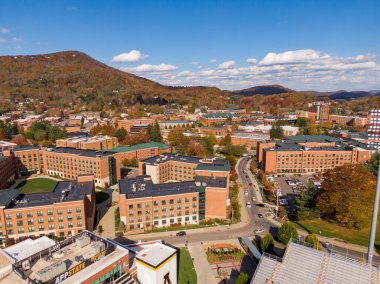 Geniş bir hava manzarası, Boone kasabası içinde yer alan Appalachian Eyalet Üniversitesi kampüsünü yakalar. Sahne, Blue Ridge 'in canlı sonbahar sırtlarıyla çevrili akademik binaları ve yerel caddeleri gösteriyor..