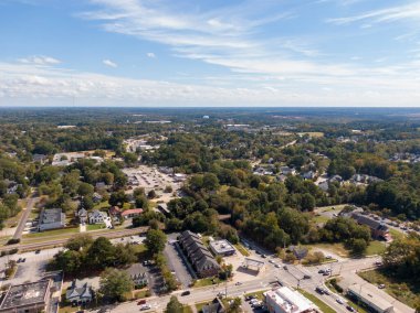 Kuzey Carolina, Apex 'in genişleyen yerleşim ve sanayi kenar mahallelerinin güneyine bakan hava manzarası. Çekim, yoğun orman örtüleri, şehir merkezindeki gelişmeler ve parlak, parçalı bulutlu gökyüzü altındaki ticari tesislerin bir karışımını yakalıyor..