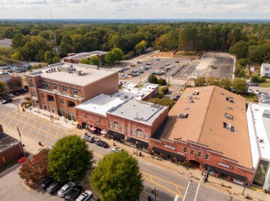 Kuzey Carolina 'nın Apex kentindeki Salem Caddesi' nin havadan görünüşü, Tütün ve Katır Borsası ve Salem Sokağı Avlusu gibi tarihi tuğla mağazaları içeriyor. Çekimde hareketli kaldırımlar, sokak parkı ve parlak bir gökyüzünün altında sonbahar ağaçları görülüyor..