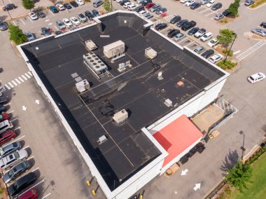 Bu hava aracı görüntüsünde siyah EPDM zarlı ticari düz bir çatı görülüyor. Mimari detay, entegre HVAC sistemleri ve korkuluk duvarlarını vurguluyor ve endüstriyel bakım ve uzmanlaşmış çatı hizmetleri için ideal hale getiriyor..