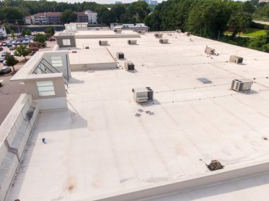 Bu hava aracı görüntüsünde, temiz montaj hatları olan büyük beyaz bir halka arz tavanı görülüyor. Yüksek açılı çekim çoklu havalandırma ve mekanik havalandırma delikleri yakalıyor. Bu da profesyonel bina zarfı bakımı ve sanayi ölçeğini gösteriyor..