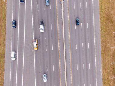 Bu yukarıdan aşağıya doğru çekilmiş fotoğraf Kuzey Carolina 'da 40 numaralı otoban boyunca ilerleyen trafiği kaydediyor. Çeşitli arabalar ve gri asfalttaki beyaz şeritler arasında seyahat eden bir kamyonet, çimenli kahverengi omuzlarla çevrili..