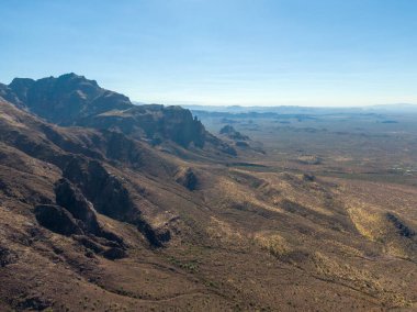 AZ 'deki Altın Kanyon' daki Batıl İnanç Dağları 'nın derin volkanik kanyonlarına ve sivri uçlu sırtlarına hava aracı görüntüsü. Gölge ve ışık, bu engebeli Arizona dağ sırası ve yaban hayatının sarp kayalıklarını ve kurak vadilerini tanımlar..