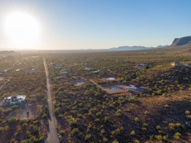 Arizona, Gold Canyon 'daki çöl yerleşim bölgesine bakan hava aracı görüntüsü. Havuzu olan lüks evler öğleden sonra saatlerinde ender Sonoran Çölü bitki örtüsü ve Batıl inanç Dağları yakınlarındaki yuvarlanan tepelerin arasına kurulmuştur..