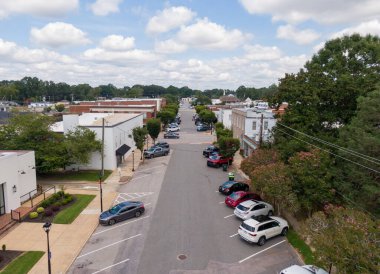 Wendell, Kuzey Carolina 'da ticari bir caddeye bakan bir hava aracı görüntüsü. Çekim, birkaç araba, tarihi tuğla binalar ve kaldırım boyunca uzanan bereketli yaz ağaçları ile sokak otoparkını yakalıyor..