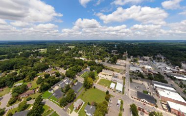 Wendell, Kuzey Carolina üzerinde yüksek irtifa hava aracı görüntüsü. Çekim, parlak bir yaz gökyüzü altında yerleşim bölgeleri, ticari bölgeler ve yoğun yeşil ormanların bir karışımını yakalıyor..