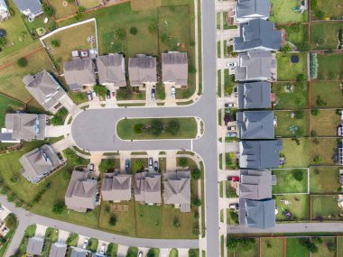 Wendell, Kuzey Carolina 'da bir banliyö batakhanesinin tepeden aşağı insansız hava aracı görüntüsü. Görüntü, modern tek aile evlerinin, karanlık asfalt sokakların ve parlak bir yaz gününün ışığında düzgünce manikürlü yeşil çimlerin simetrik bir planını gösteriyor..