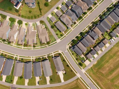 Wendell, Kuzey Carolina 'da bir banliyö batakhanesinin tepeden aşağı insansız hava aracı görüntüsü. Görüntü, modern tek aile evlerinin, karanlık asfalt sokakların ve parlak bir yaz gününün ışığında düzgünce manikürlü yeşil çimlerin simetrik bir planını gösteriyor..