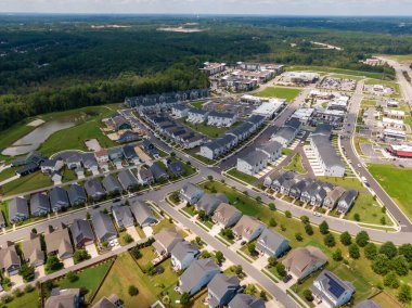 Wendell, Kuzey Carolina 'nın hava aracı görüntüsü, modern bir karma kullanım gelişimini yakalıyor. Görüntüde, parlak, açık bir yaz gökyüzü altında yeni bir ticari perakende bölgesine komşu çağdaş kasaba evleri ve tek aile evleri yer alıyor..