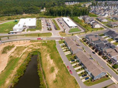 Wendell, Kuzey Carolina 'nın hava aracı görüntüsü modern bir okul tesisinin yakınındaki acil durum itfaiye araçlarını gösteriyor. Sahnede bir dizi kasaba evi, okul otobüsleri olan büyük bir otopark ve parlak bir yaz güneşinin altında bir dinlenme havuzu yer alıyor..