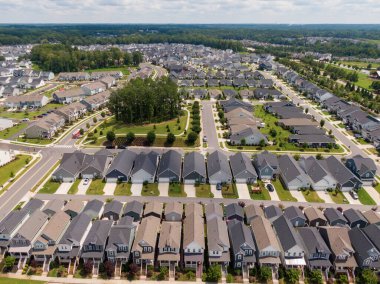 Wendell, Kuzey Carolina 'nın yüksek açılı insansız hava aracı görüntüsü, yoğun bir modern yerleşim bölgesi içeriyor. Çekimler, çağdaş tek aile evleri, manikürlü çimenler ve parlak, açık bir yaz gökyüzü altında dolambaçlı banliyö sokaklarını vurguluyor..