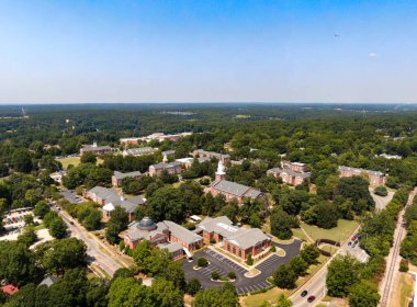 Wake Forest, NC 'nin yüksek açılı insansız hava aracı görüntüsü. Çekim merkezleri Güney White Caddesi 'nin tuğla dükkanları, tarihi bölgenin çapraz park alanı, Rönesans Merkezi ve SEBTS kampüsünün yemyeşil gölgeliği..
