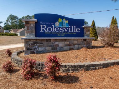 Rolesville, Kuzey Carolina 'nın büyük taş heykel giriş tabelasının zemin katındaki çekimi. Mavi tabela 