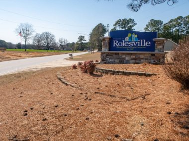 Rolesville, Kuzey Carolina 'nın büyük taş heykel giriş tabelasının zemin katındaki çekimi. Mavi tabela 