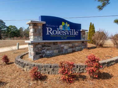 Rolesville, Kuzey Carolina 'nın büyük taş heykel giriş tabelasının zemin katındaki çekimi. Mavi tabela 