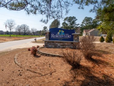 Rolesville, Kuzey Carolina 'nın büyük taş heykel giriş tabelasının zemin katındaki çekimi. Mavi tabela 