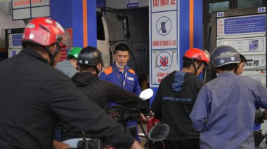 Sa Pa, Vietnam - 29 Temmuz 2025: Birçok motosikletli görünür tabela ve pompaları olan bir benzin istasyonunda kuyrukta bekliyor