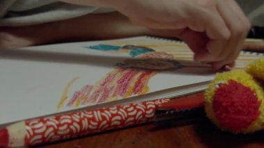 Akşam yemeğinden önce ahşap yemek masasında anne-oğul ellerinin pastel boyayla çizimlerini kapat. Yüksek kalite 4k görüntü