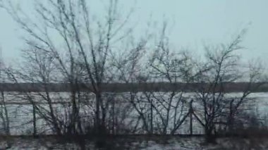 Kış boyunca Tempelhof 'a bakan bir trenden görüntü. Karlı şehir manzaraları, kentsel binalar ve donmuş açık alanlar soğuk mevsimsel bir atmosfer yaratır. Yüksek kalite 4k görüntü