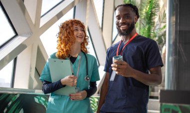 Doktorlar ve doktorlar hastane kafeteryasındaki dijital tabletlerin hasta tabletlerini hastane kafeteryasındaki dijital tabletlerin çizelgelerini tartışıyorlar. Yüksek kalite fotoğraf