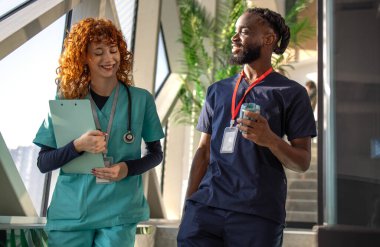 Doktorlar ve doktorlar hastane kafeteryasındaki dijital tabletlerin hasta tabletlerini hastane kafeteryasındaki dijital tabletlerin çizelgelerini tartışıyorlar. Yüksek kalite fotoğraf