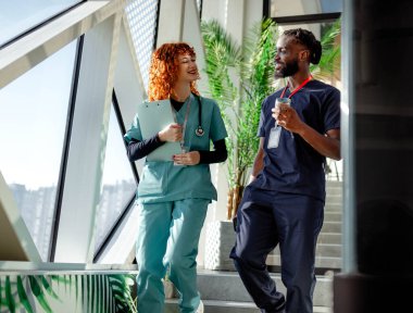 Tıp fakültesi içinde yürürken iletişim kuran bir sürü genç öğrenci tıp fakültesine geliyor. Yüksek kalite fotoğraf