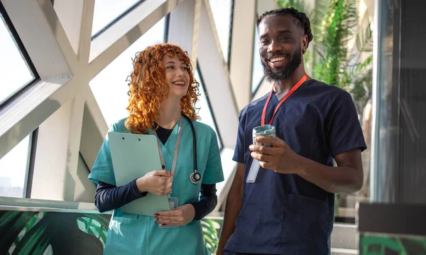 Doktorlar ve doktorlar hastane kafeteryasındaki dijital tabletlerin hasta tabletlerini hastane kafeteryasındaki dijital tabletlerin çizelgelerini tartışıyorlar. Yüksek kalite fotoğraf