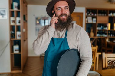 Cafe 'de cep telefonu kullanırken mutlu ol. Bir kafede cep telefonu kullanan yüksek kalite fotoğraf çeken mutlu barista.