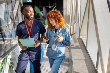 Kahve molası sırasında konuşan iki genç tıp öğrencisi hastane kafeteryasında kahve molası sırasında konuşuyorlardı. Yüksek kalite fotoğraf