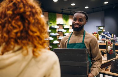 Ayakkabı mağazasında kutu taşıyan bir ayakkabı satıcısı. Ayakkabı mağazasında kutu taşıyan kaliteli bir ayakkabı satıcısı.