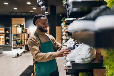 Ayakkabı mağazasında kutu taşıyan bir ayakkabı satıcısı. Ayakkabı mağazasında kutu taşıyan kaliteli bir ayakkabı satıcısı.