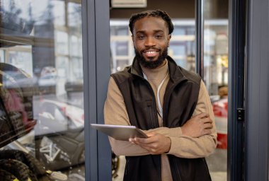 Elinde tablet tutan motosiklet malzemeleri satıcısı. Elinde tablet tutan yüksek kaliteli motosiklet ekipmanı satıcısı.