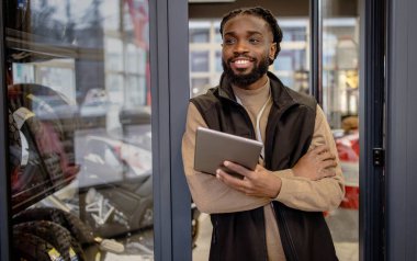 Elinde tablet tutan motosiklet malzemeleri satıcısı. Elinde tablet tutan yüksek kaliteli motosiklet ekipmanı satıcısı.