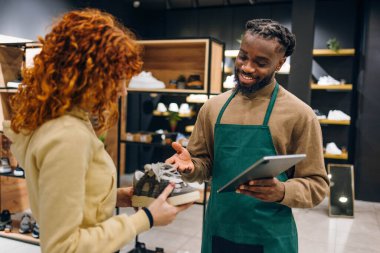 Ayakkabı mağazasında müşteri ve satıcı. Ayakkabı mağazasında yüksek kaliteli fotoğrafçı ve satıcı