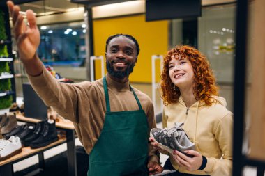 Ayakkabı mağazasında müşteri ve satıcı. Ayakkabı mağazasında yüksek kaliteli fotoğrafçı ve satıcı