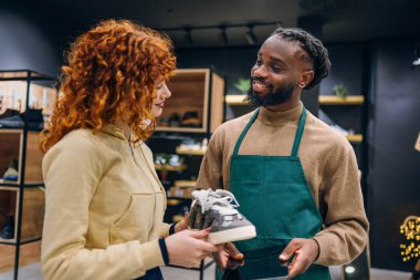 Ayakkabı mağazasında müşteri ve satıcı. Ayakkabı mağazasında yüksek kaliteli fotoğrafçı ve satıcı
