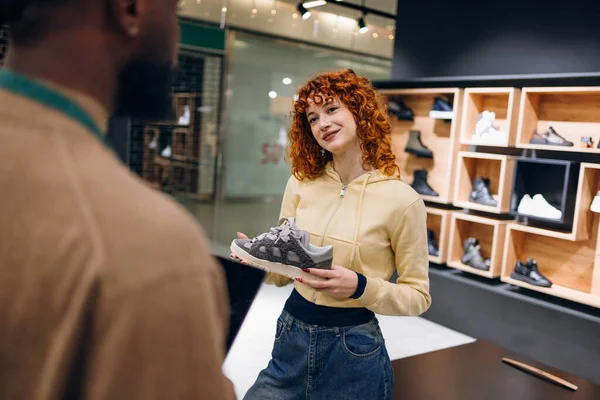 Mağazadaki ayakkabı satıcısı. Bir mağazada yüksek kaliteli fotoğraf satıcısı.