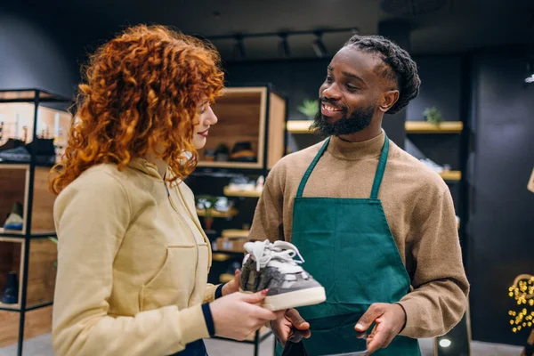 Ayakkabı mağazasında müşteri ve satıcı. Ayakkabı mağazasında yüksek kaliteli fotoğrafçı ve satıcı