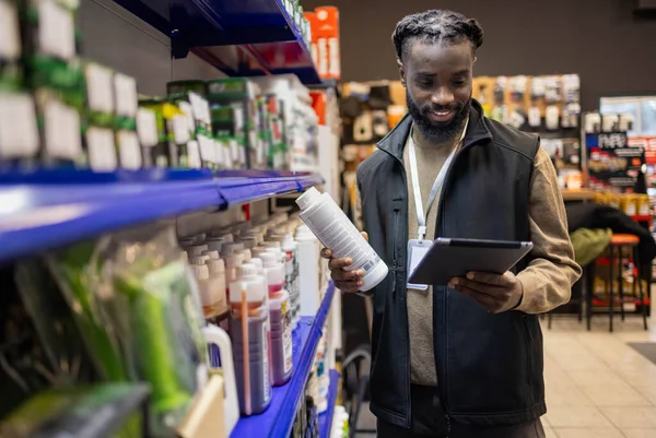 Elinde tablet tutan motosiklet malzemeleri satıcısı. Motosiklet malzemeleri satıcısı elinde tablet tutuyor.