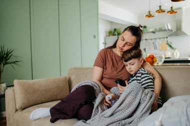 Annem oğlanlara burun spreyi sıkar. Yüksek kaliteli fotograf. Çocuklar burun spreyi sıkar.