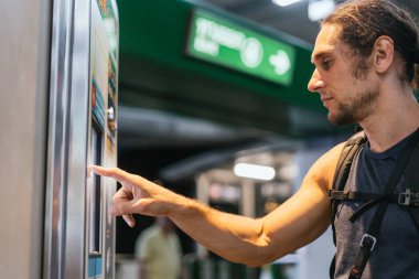 Otomatik otomatikman tren bileti alan bir adam.