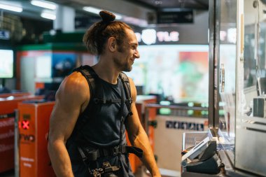 Sırt çantalı ve kameralı bir adam nakliye istasyonundan bilet alıyor.